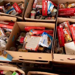 Boxes full of donated food stacked on other boxes of donated food