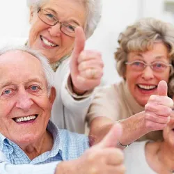 Three senior citizens with their thumbs up in approval