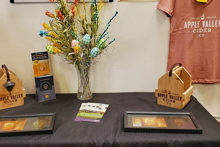 A display of awards and merchandise for Apple Valley Cider Co.